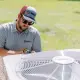 Hall technician servicing an HVAC unit outside home.