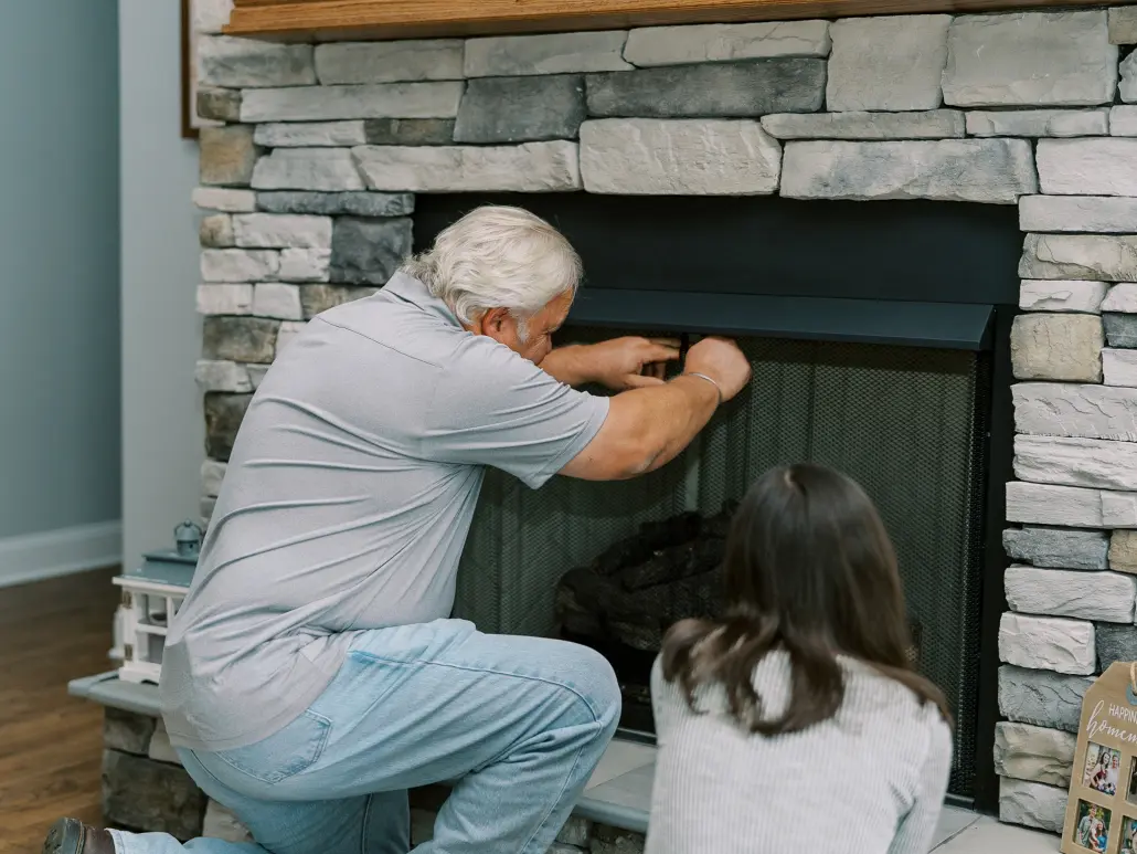 technician inspecting propane fireplace during service plan visit