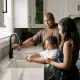 Family in kitchen washing hands using propane heated water