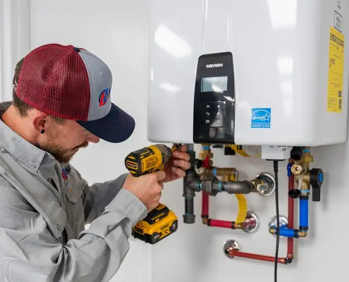 Hall technician performing maintenance on a tankless water heater