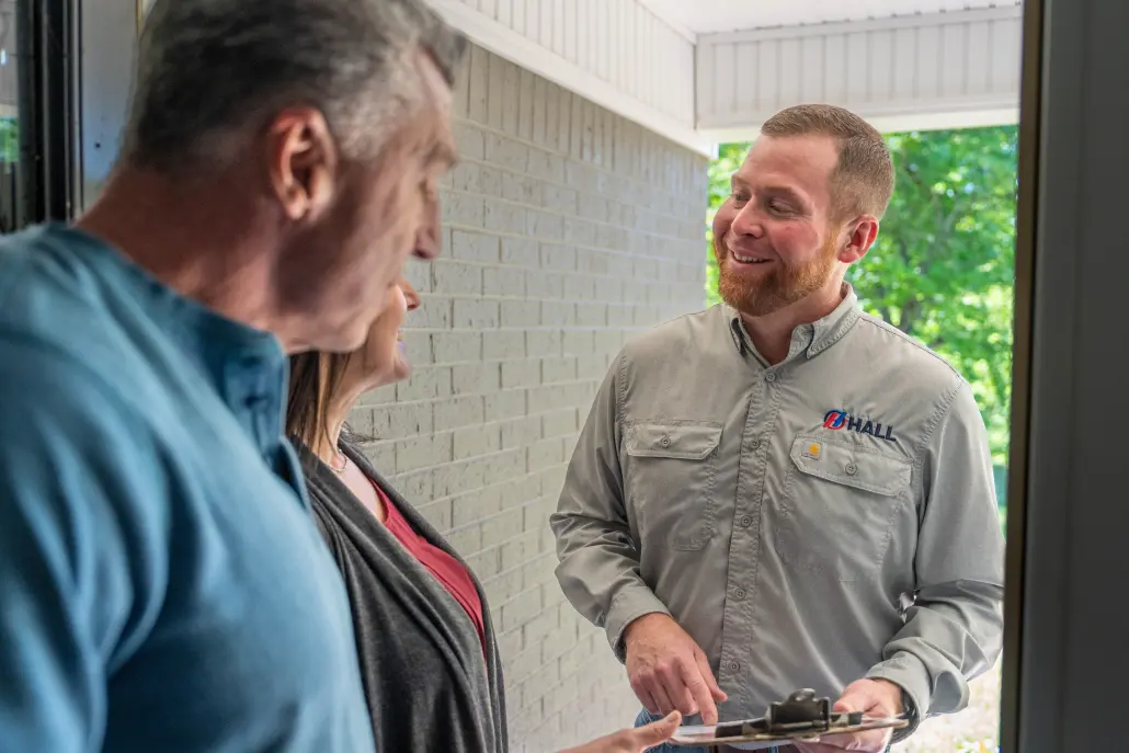HVAC technician greeting homeowners