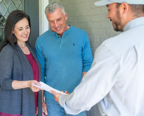 Hall service tech handing paperwork to customers