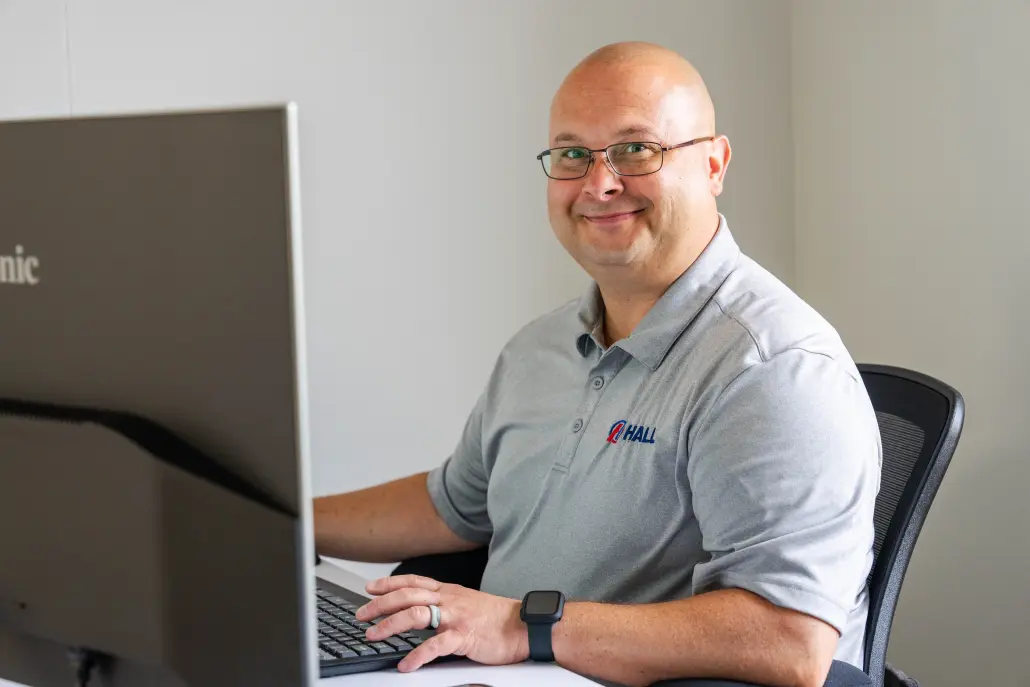 DSC03603-Edit Hall employee smiling at computer