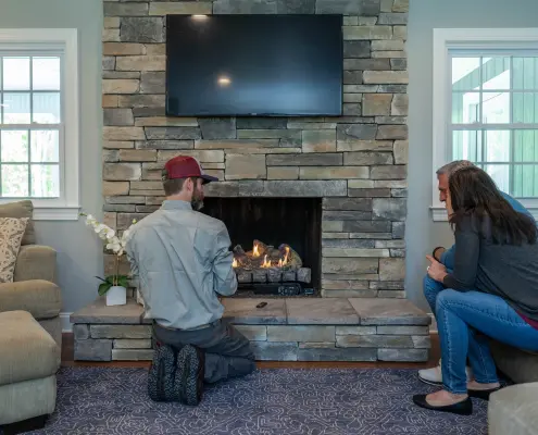 Hall technician servicing a gas log set.