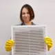 Woman holding dirty and dusty air filter