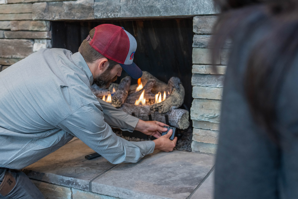 Hall technician installing a gas log set.