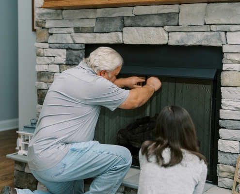 technician inspecting propane fireplace during service plan visit