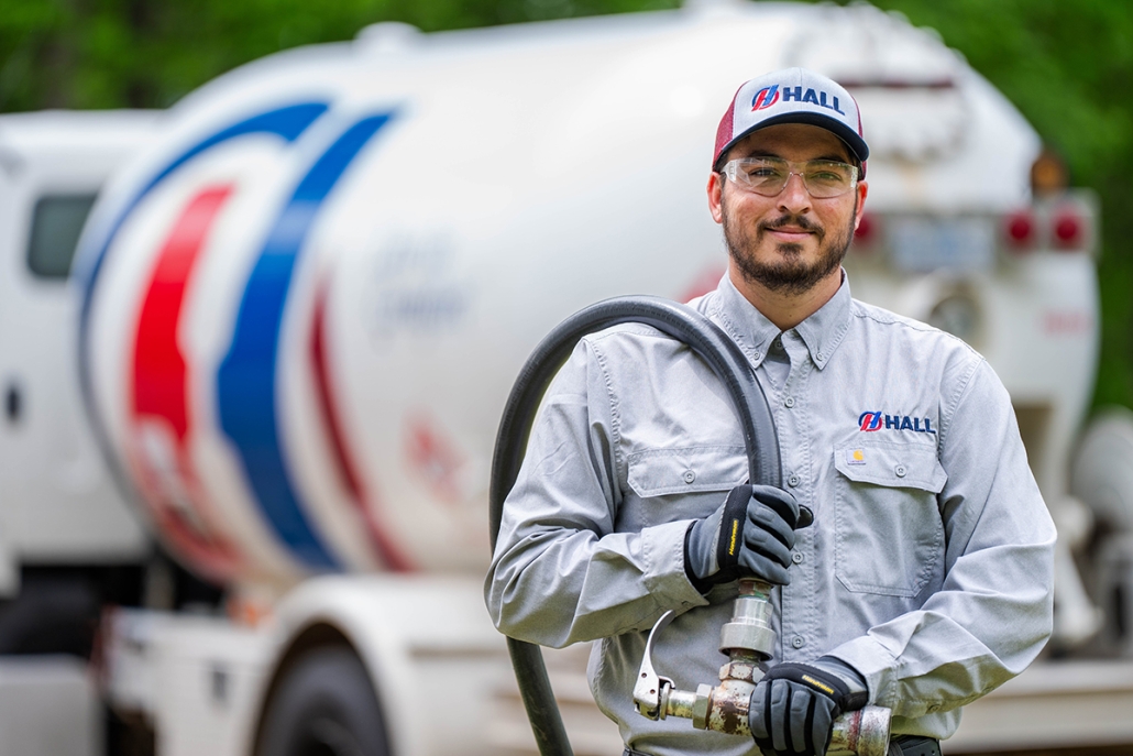 Hall technician pulling fill line from truck to refill propane tank