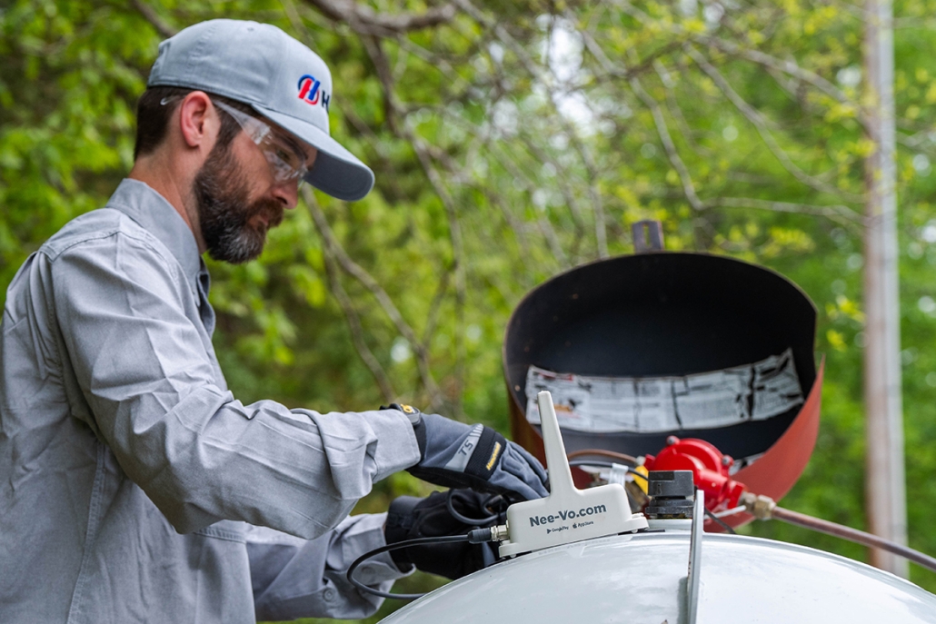 Hall technician refilling a propane tank with remote tank monitoring installed