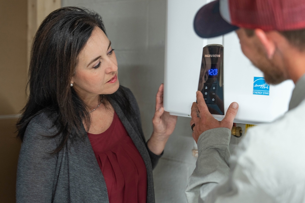 Hall technician showing tankless water heater to customer