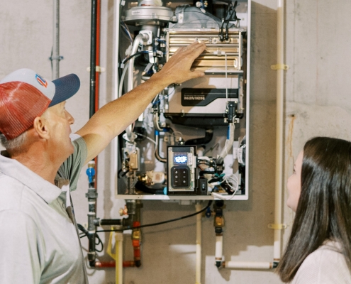 Hall technician explaining how a tankless water heater works to a customer