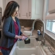 Person washing dishes in a kitchen sink