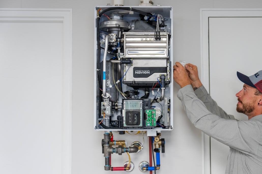 Hall technician installing a tankless water heater