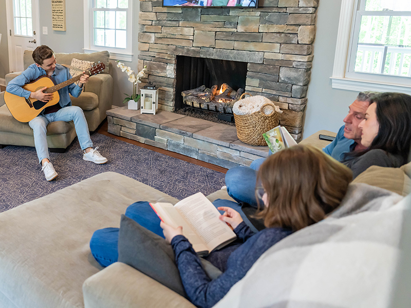 Family gathered around a propane fireplace with a generator backup