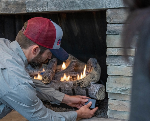 Hall technician servicing a gas log set.