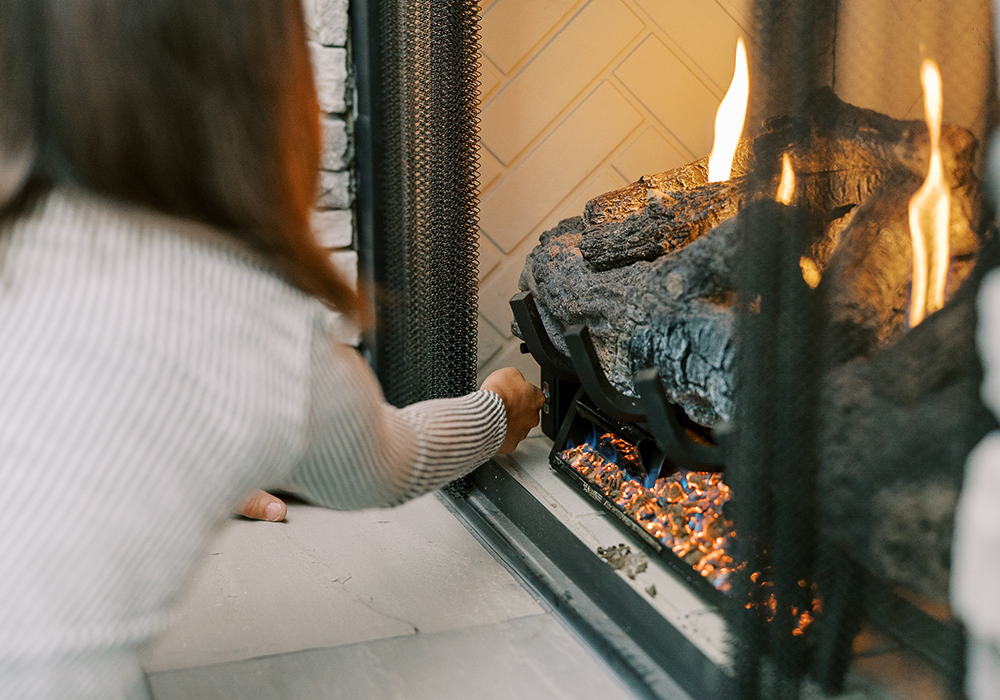 Hall customer adjusting settings on gas fireplace