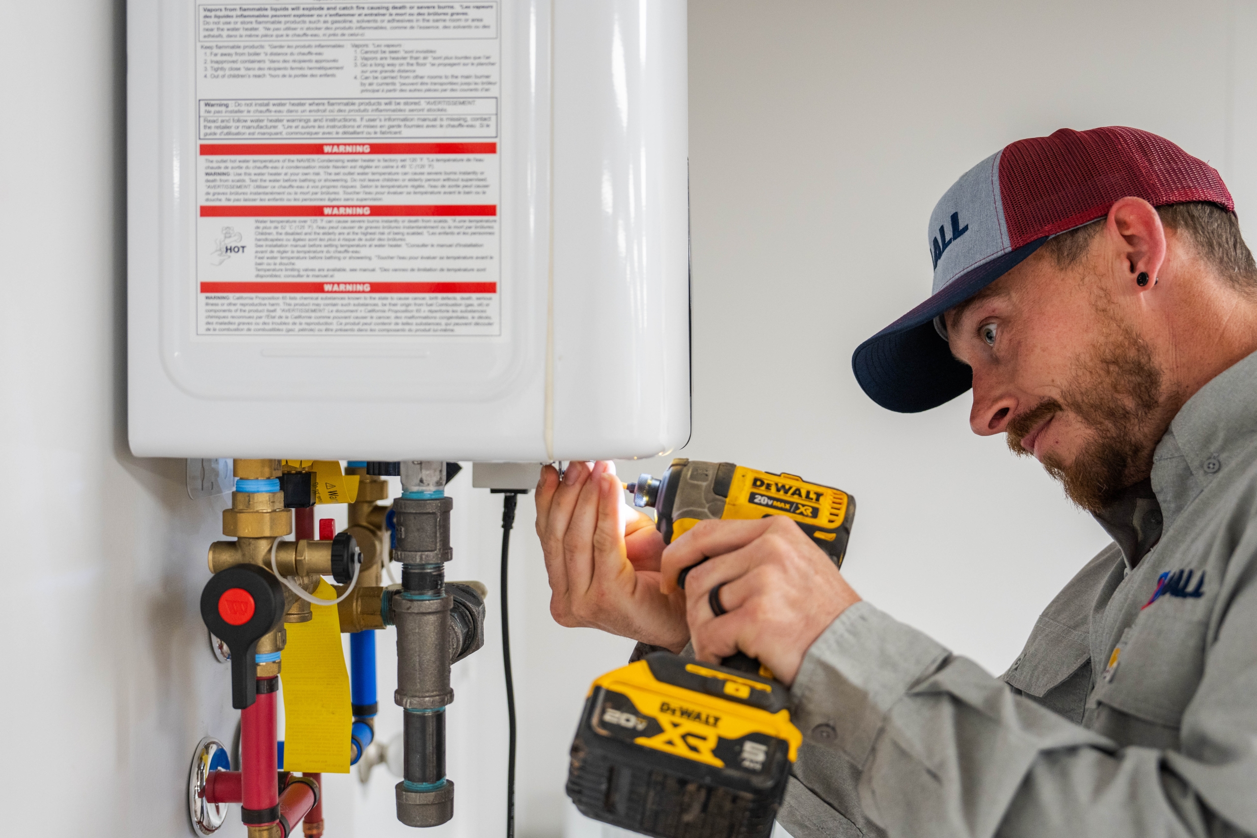 technician maintaining a tankless water heater